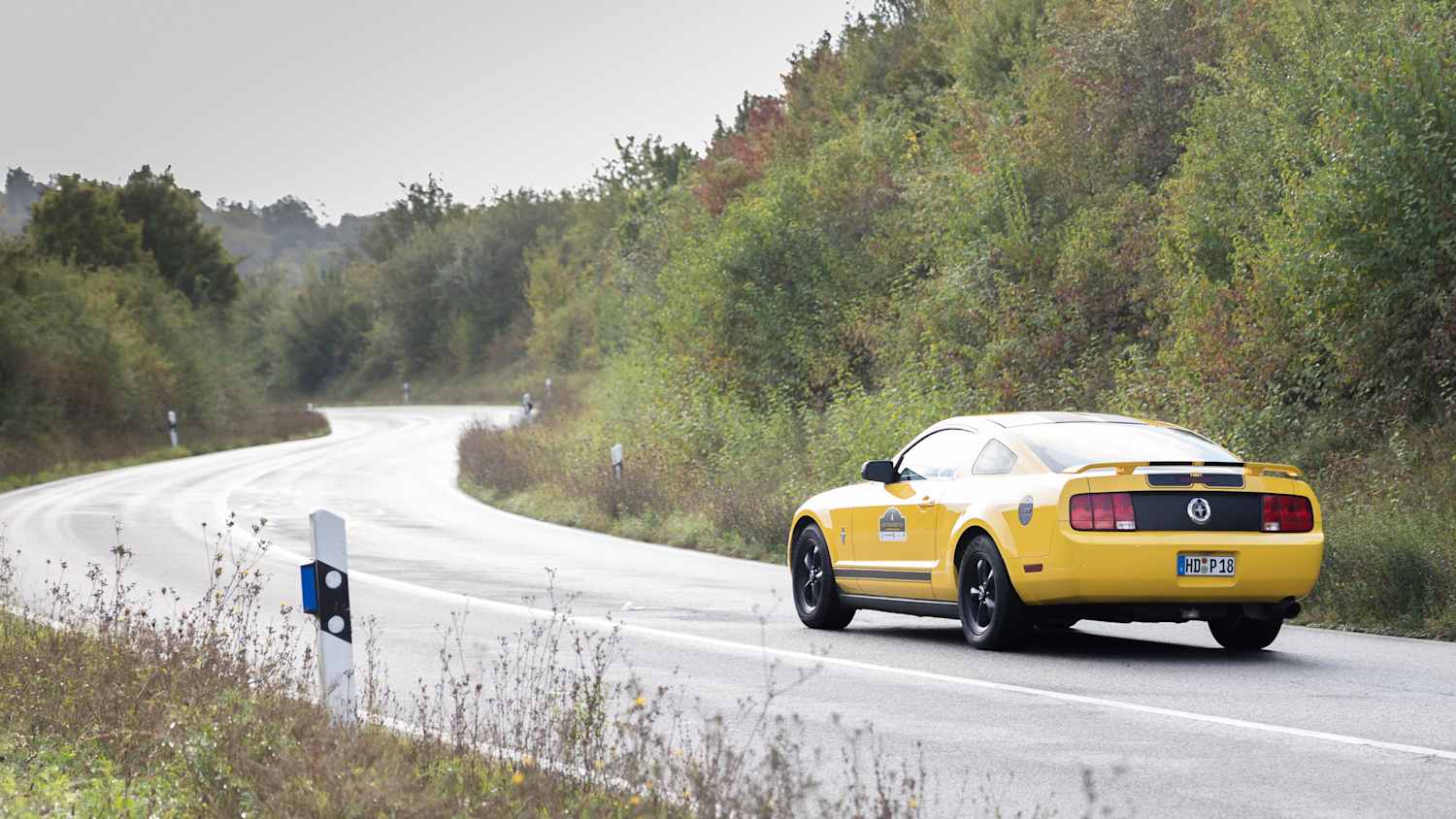 Ein gelber Youngtimer fährt auf einer Straße