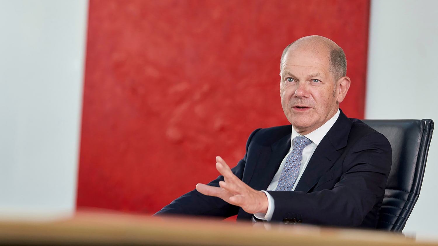Olaf Scholz gestikulierend an einem Tisch