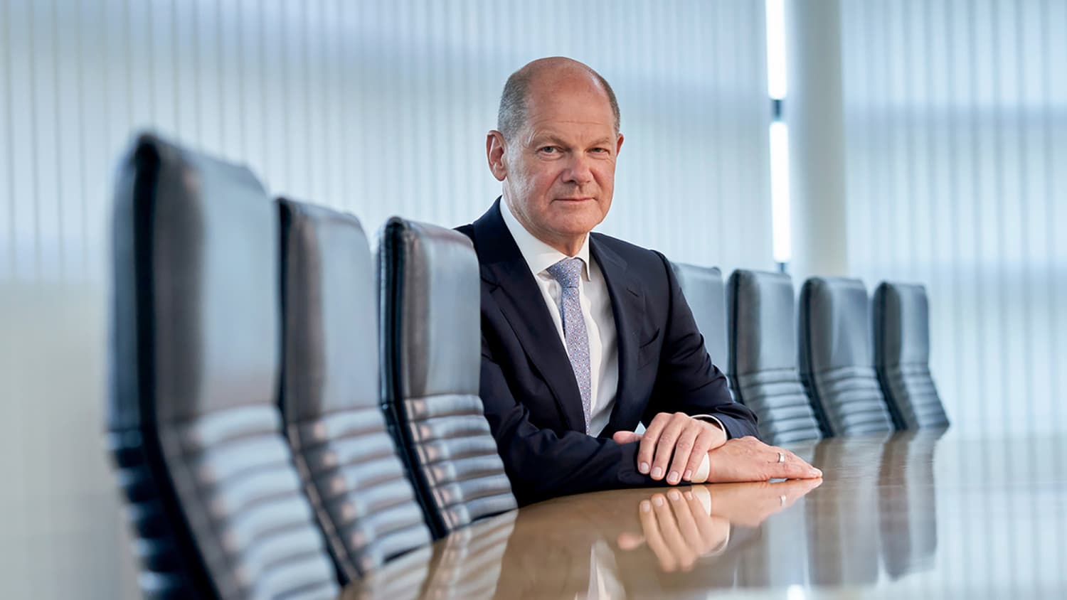 Olaf Scholz sitzt an einem Tisch