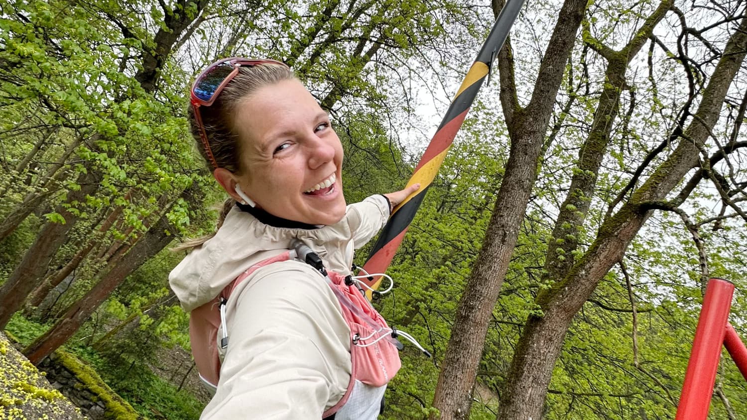 Die lachende Marathonläuferin Joyce Hübner an einem Grenzpfeiler