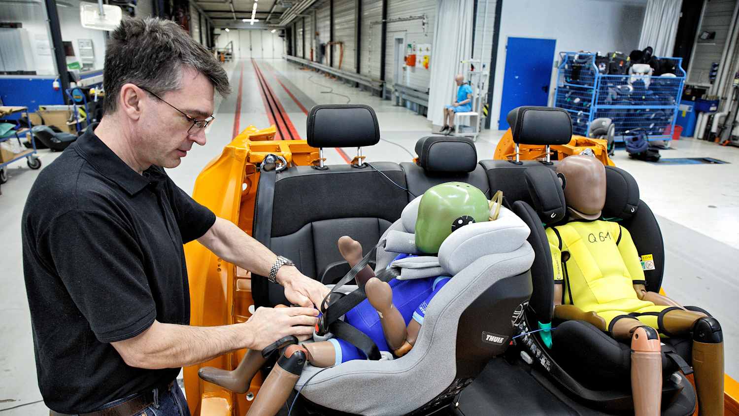 ADAC Testingenieur Andreas Ratzek montiert einen Kindersitz auf dem Testschlitten
