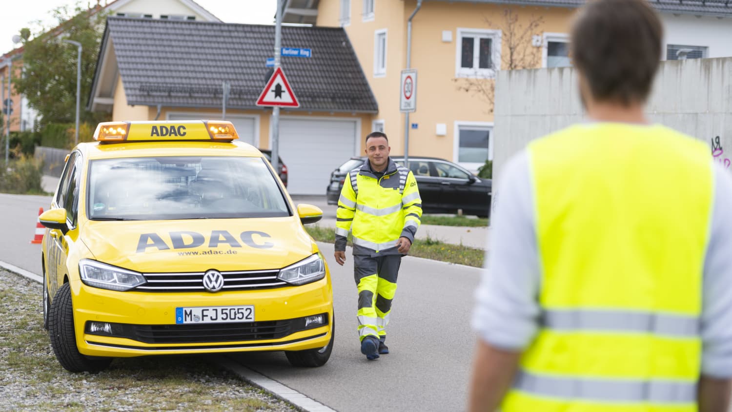 Ein Pannenhelfer läuft an seinem Auto vorbei auf einen Havaristen zu