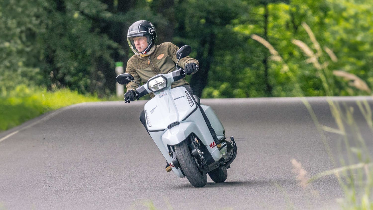 Ein Mann fährt auf einer Lambretta X125 auf einer Straße
