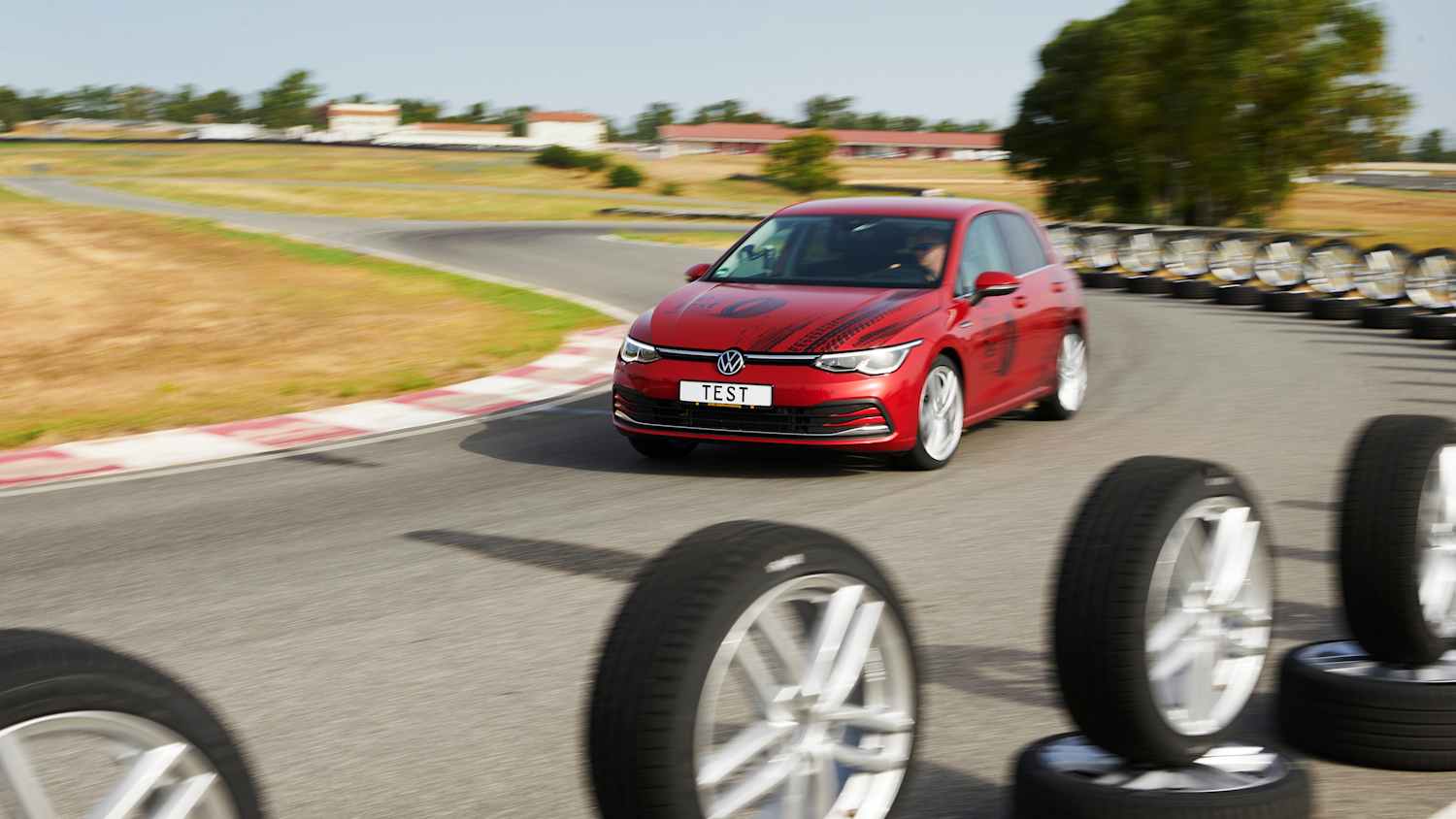 Frontansicht eines VW Golfs der an Reifen vorbei fährt, die während dem ADAC Sommerreifentest 2025 getestet wurden