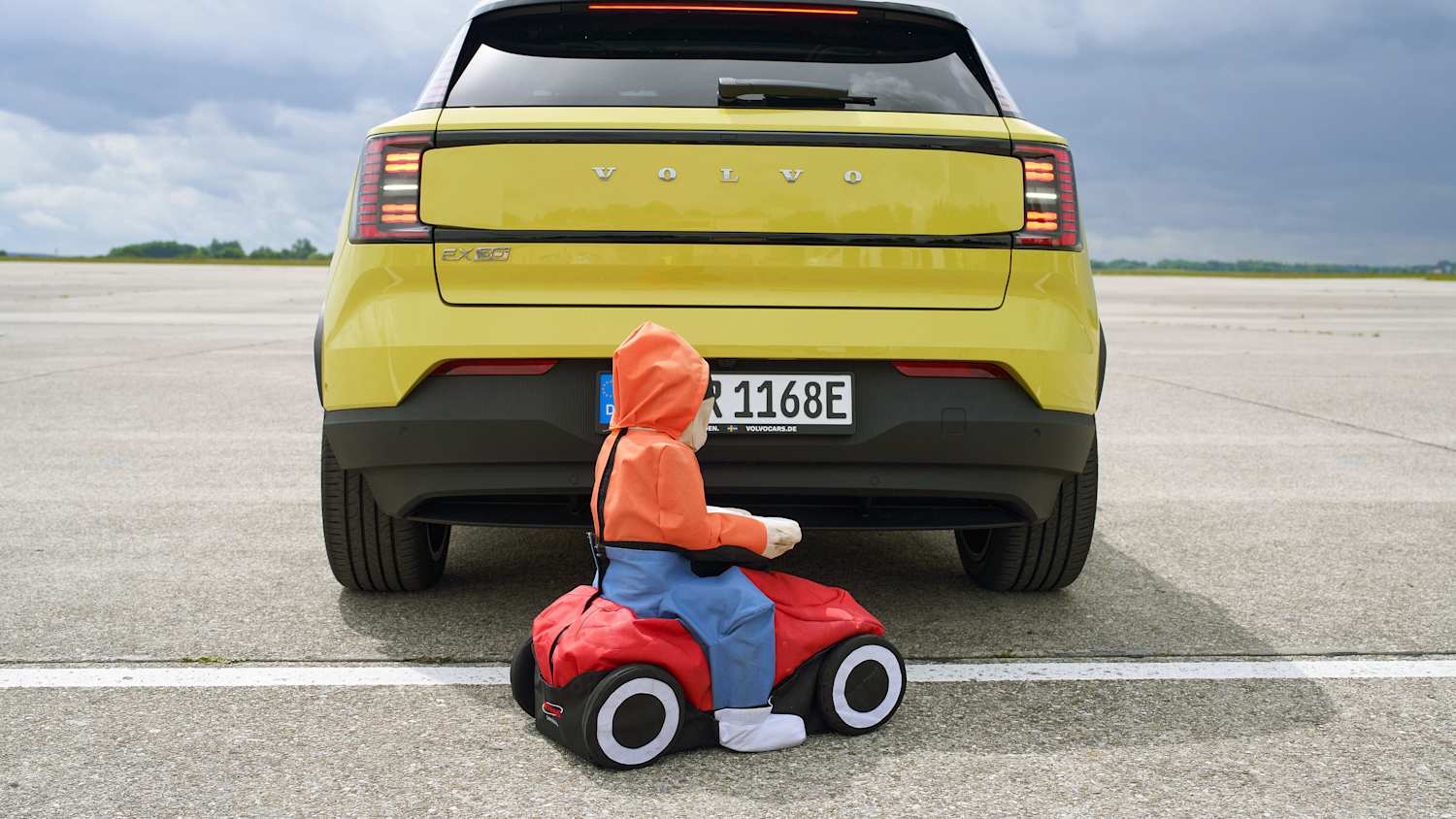 Ein Kinder Dummy auf einem Bobbycar hinter einem Volvo beim Test der Marktübersicht Notbremssysteme Rückwärts