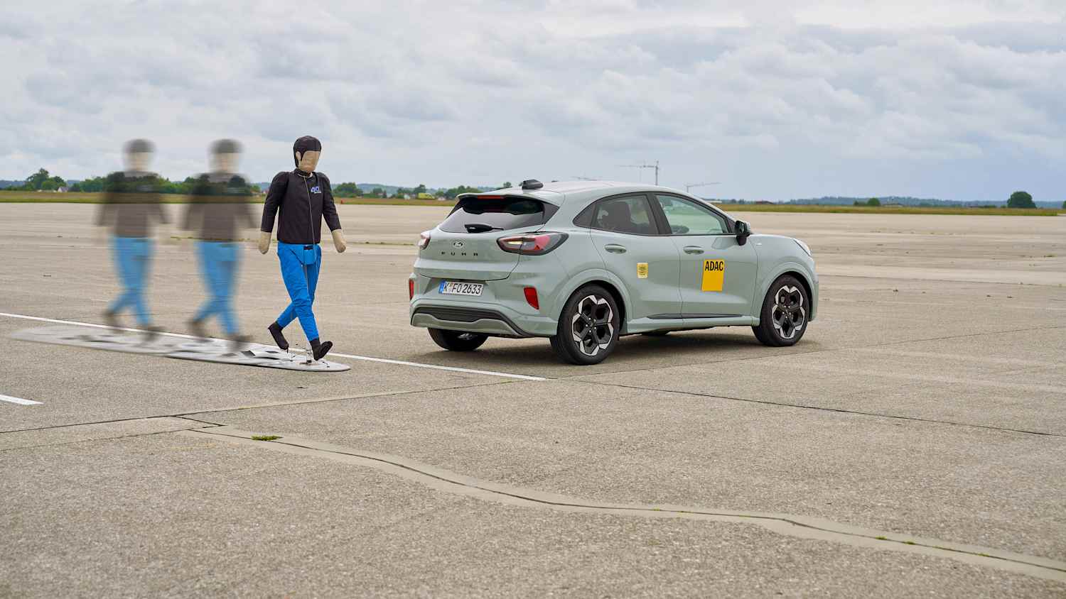 Ein Dummy läuft beim Test der Notbremssysteme hinter einem Auto