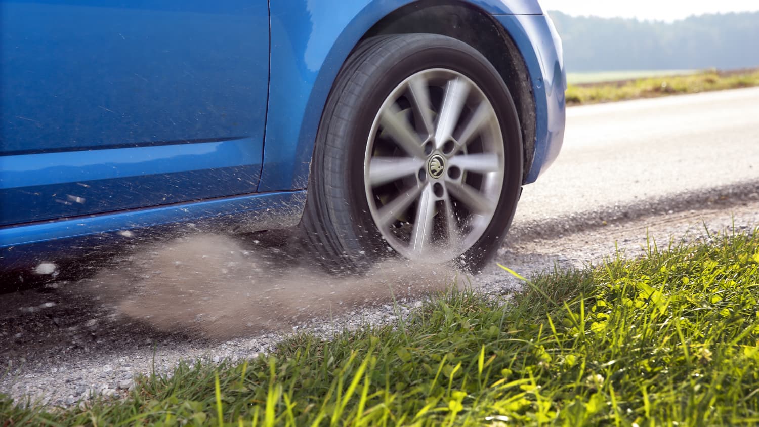 Ein blaues Auto ist auf den Seitenstreifen geraten und bremst