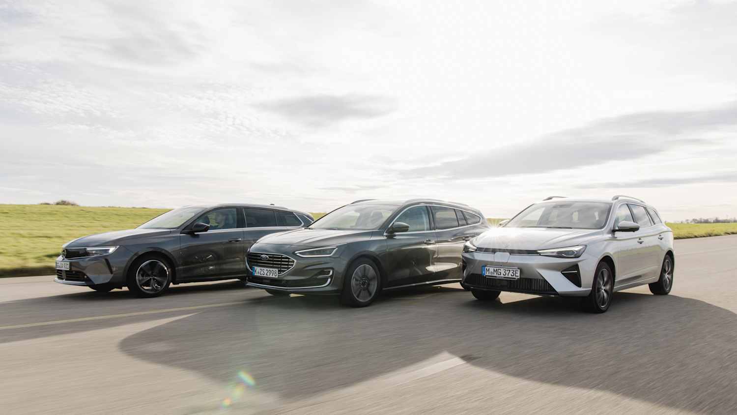 Ein Opel Astra, Ford Focus und MG5 fahren nebeneinander