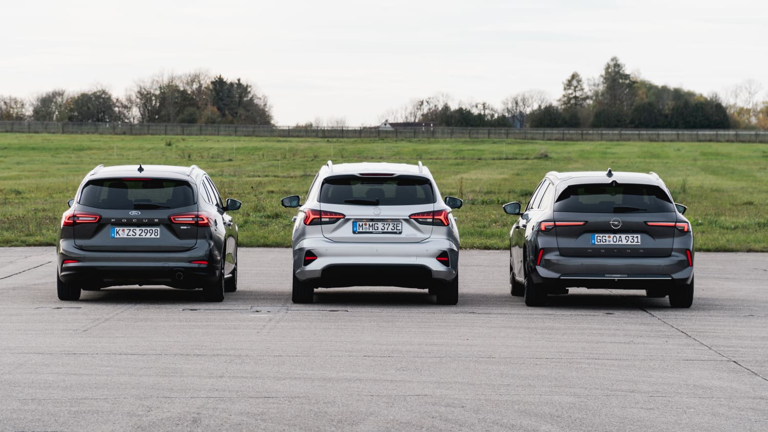 Ein Opel Astra, Ford Focus und MG5 stehen nebeneinander, Heckansicht