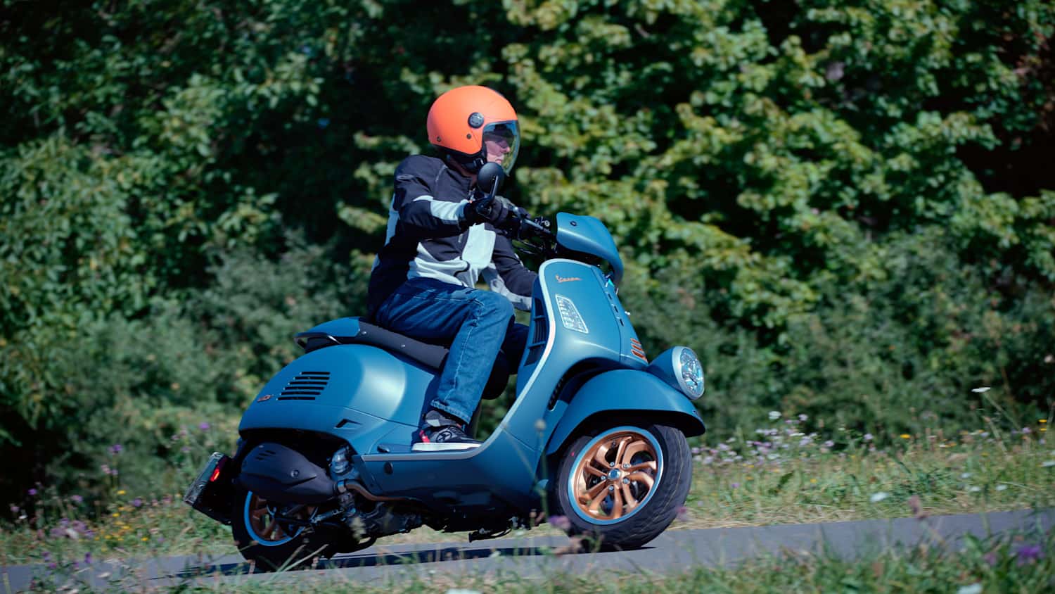 Ein Mann fährt auf einer Vespa GTV Officina 8 310 