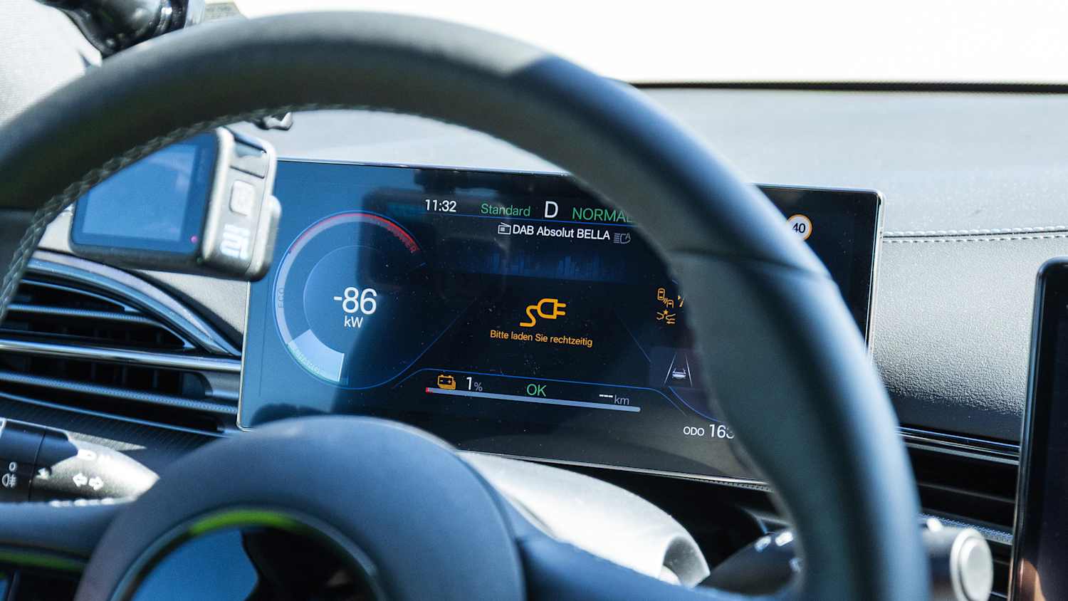 Nahaufnahme eines Elektroauto-Displays mit Batteriestatus und Reichweitenanzeige.