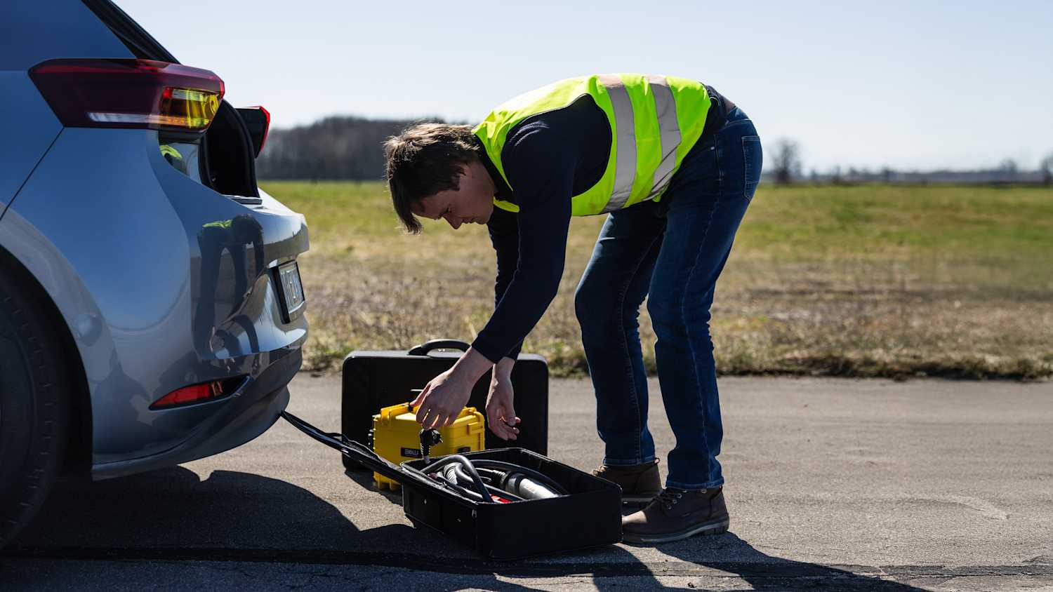 Ein Techniker läd das Elektrofahrzeug mit einer Starter-Batterie