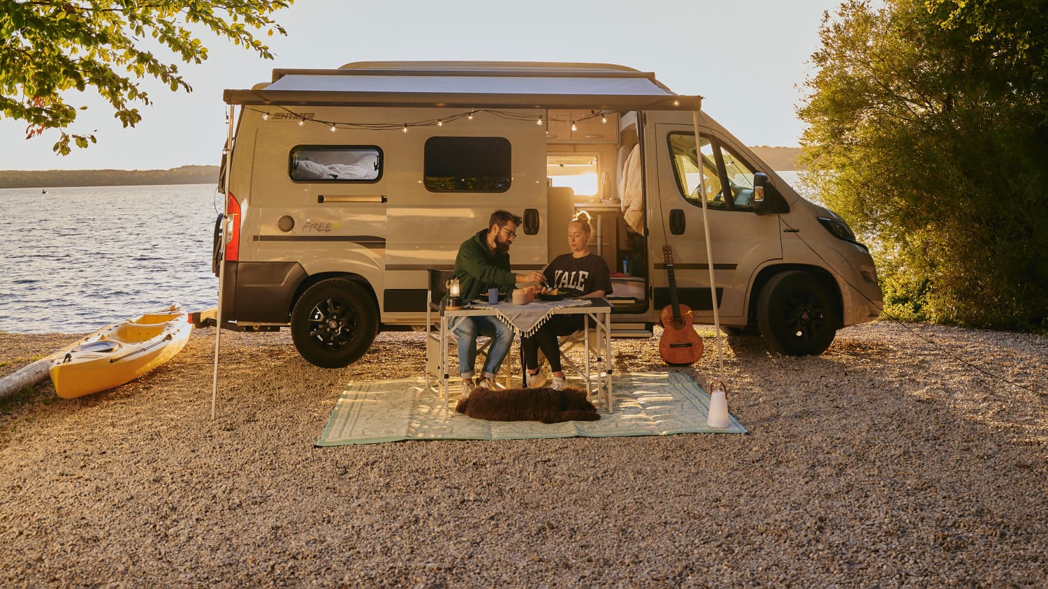 Ein Pärchen sitzt vor seinem Wohnmobil am Campingplatz Ambach