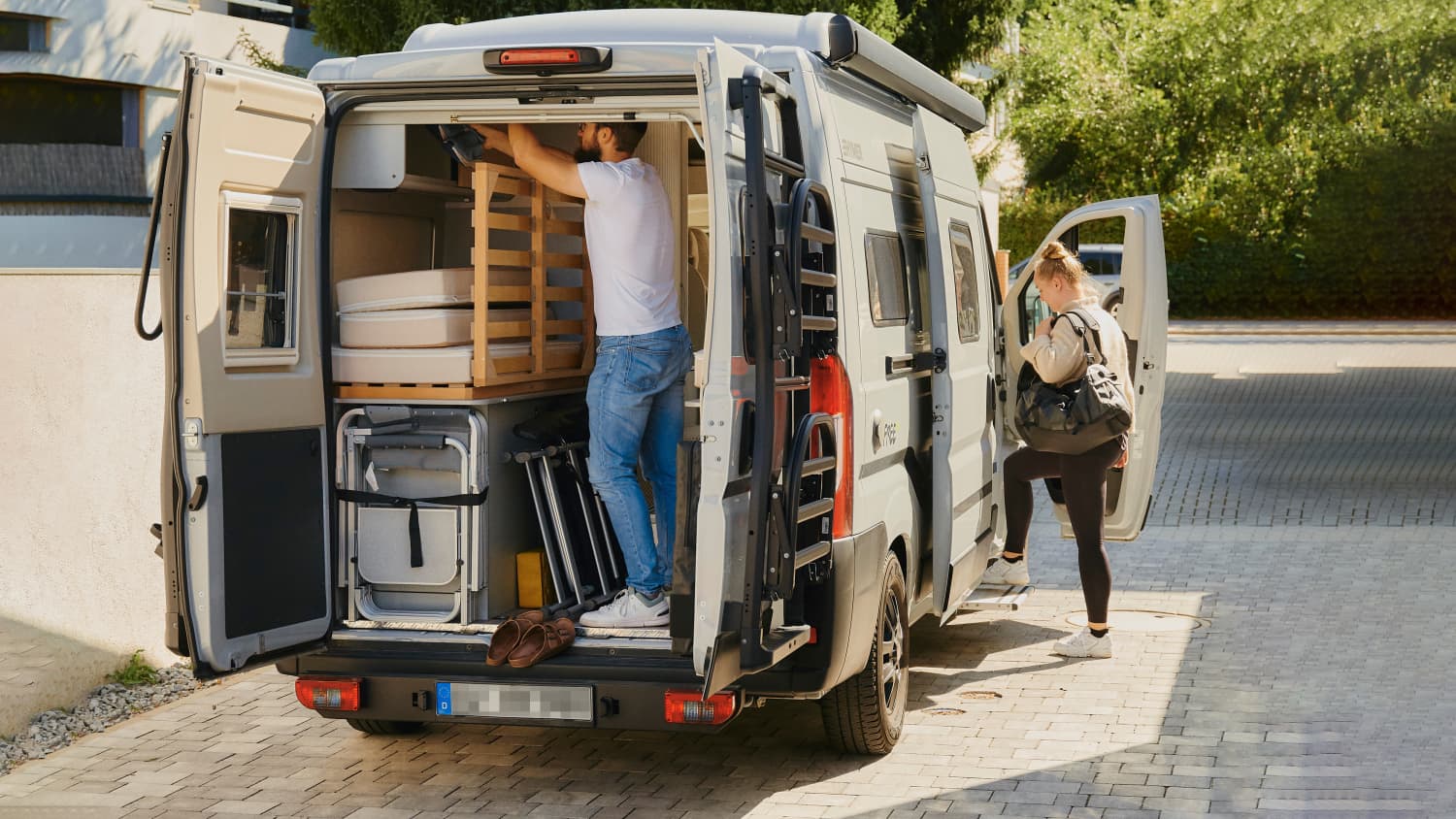 Ein Pärchen belädt sein Wohnmobil für den Urlaub