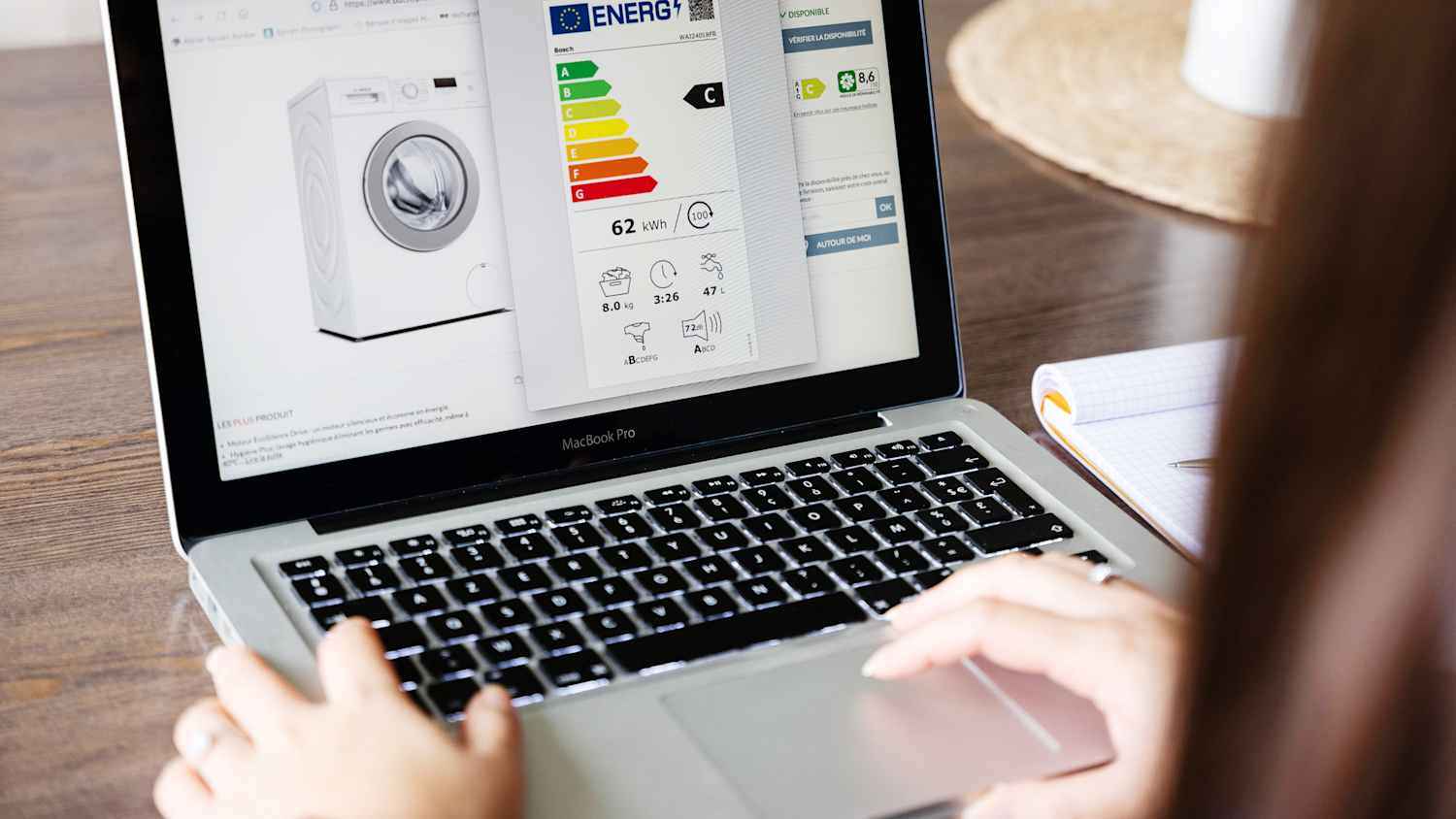 Eine Frau die sich online über die Energieeffizienzklasse einer Waschmaschine erkundigt