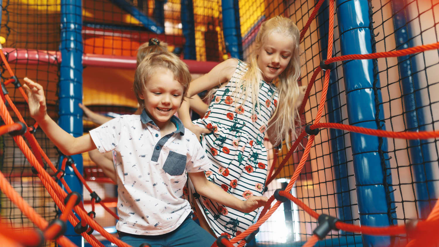Kinder krabbeln durch die Netze in eines Indoorspielplatzes
