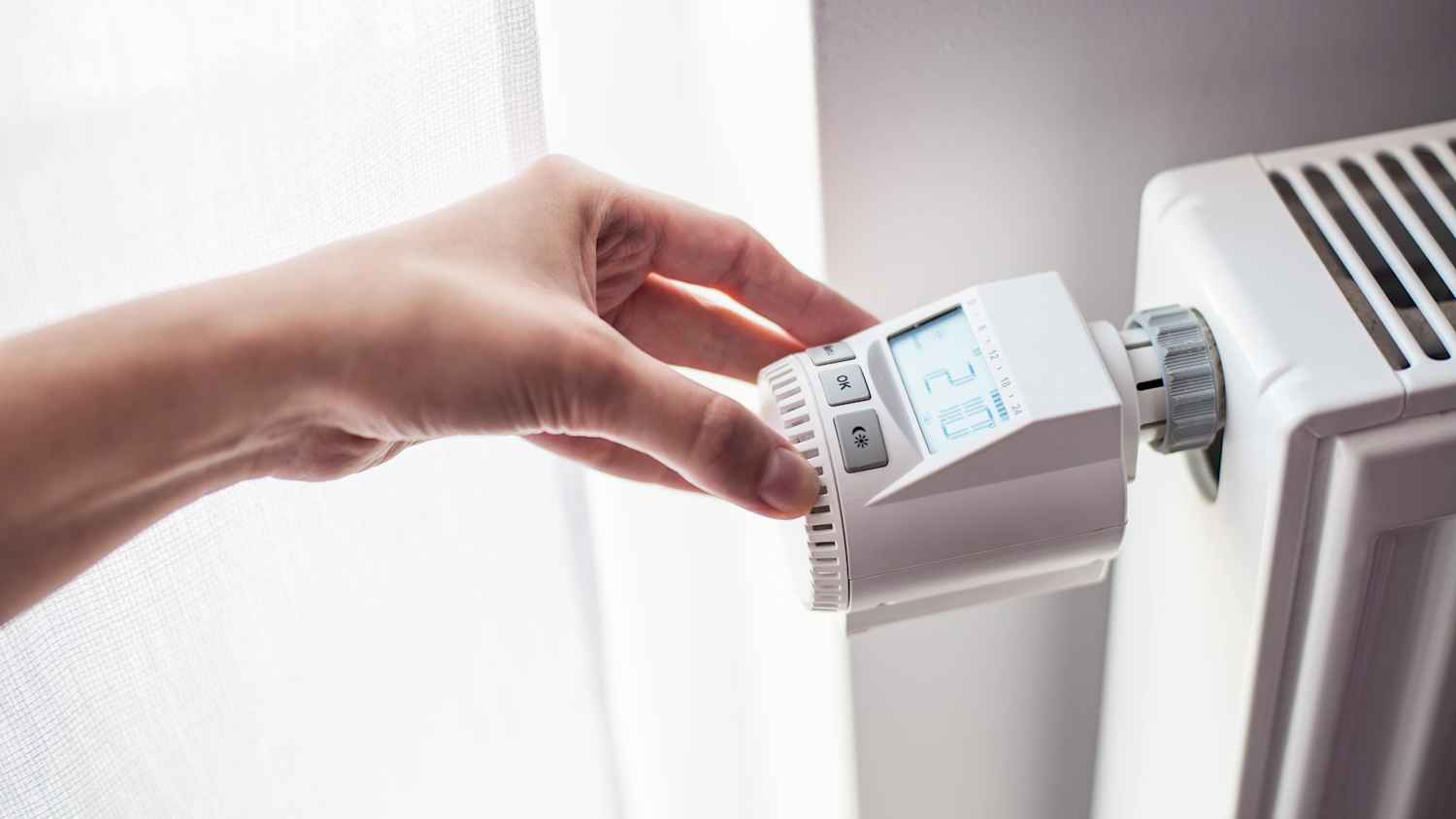Digitales Heizungsregler der von einer Frau bedient wird