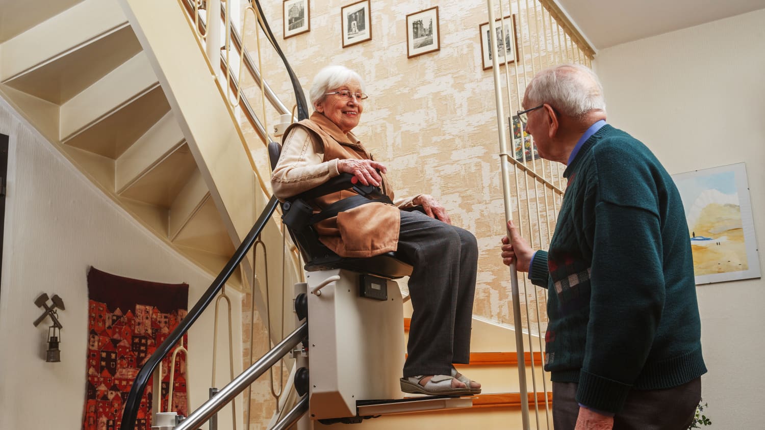 Ein Ehepaar das die Treppen mit einem Treppenlift runter fährt