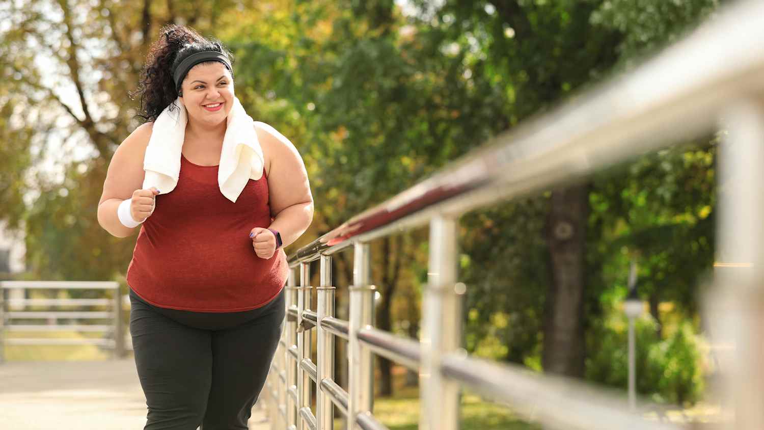 Eine übergewichtige Frau joggt in der Natur