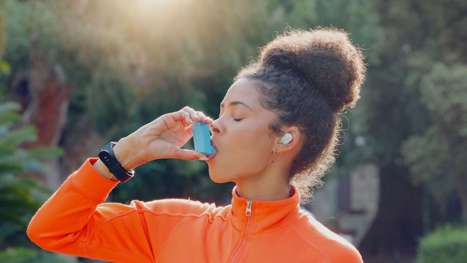 Eine Frau inhaliert mit einem Inhalator zur Unterstützung bei ihrer Asthmaerkrankung