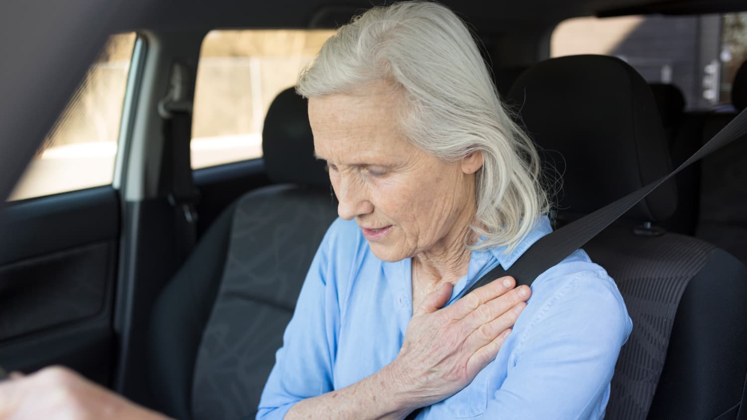 Eine Frau fasst sich wärend der Fahrt an die Brust.