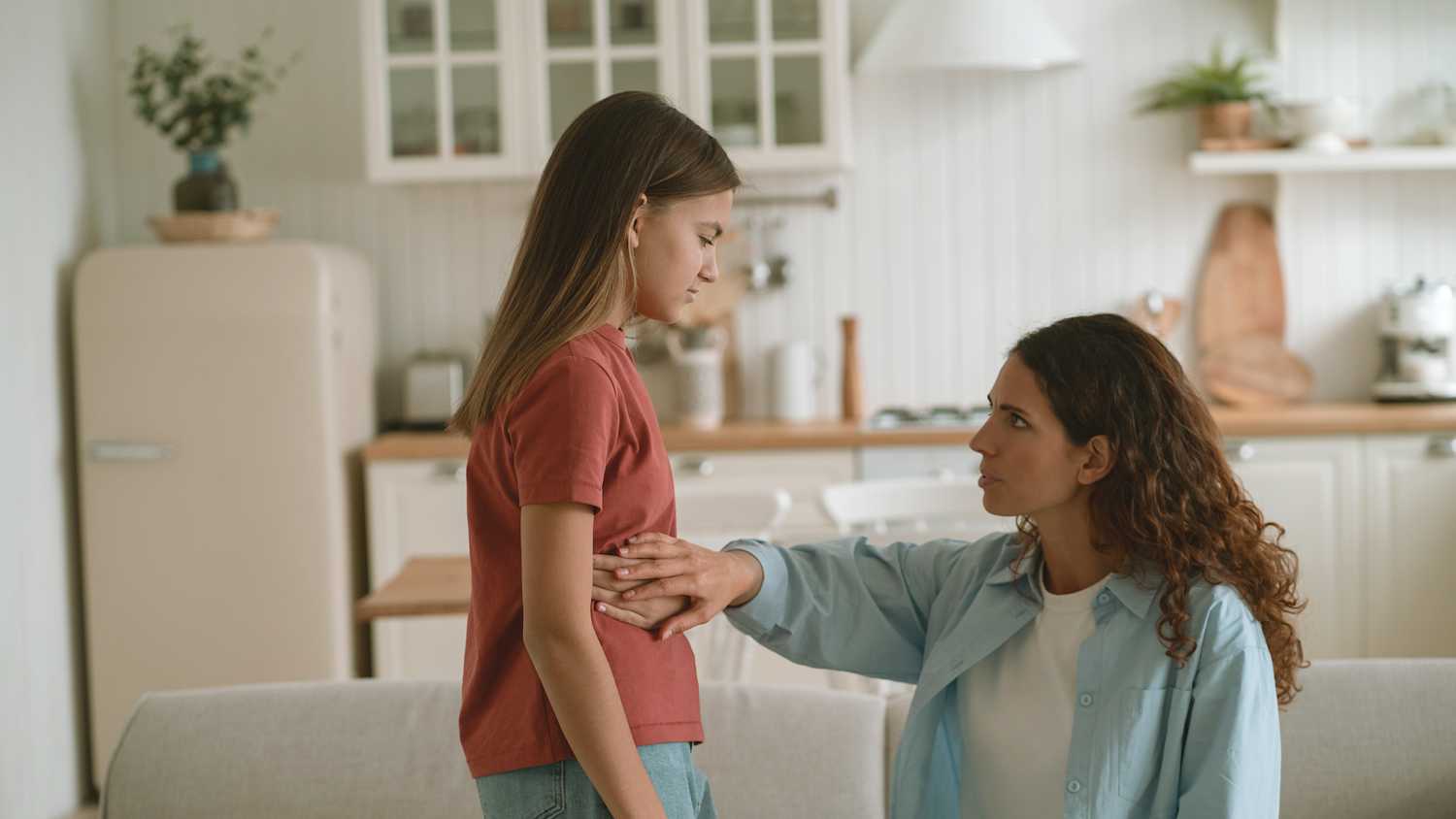 Eine Mutter tastet den Bauch Ihrer etwa neun Jährigen Tochter ab