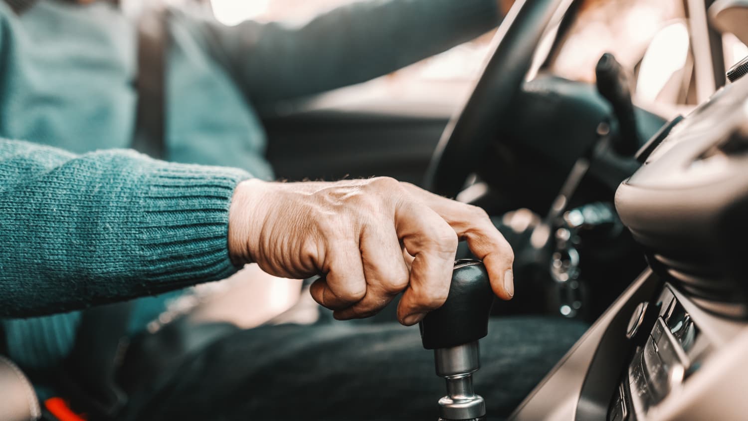 Ein älterer Mann sitzt am Steuer eines Autos