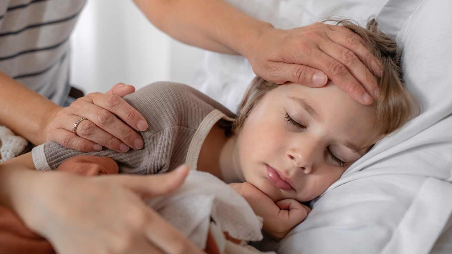 Ein krankes Kind liegt mit Fieber im Bett