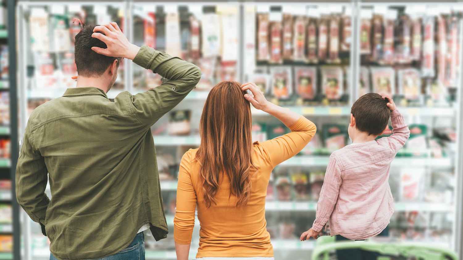 Eine Familie steht vor einem Supermarktregal und kratzt sich am Kopf.