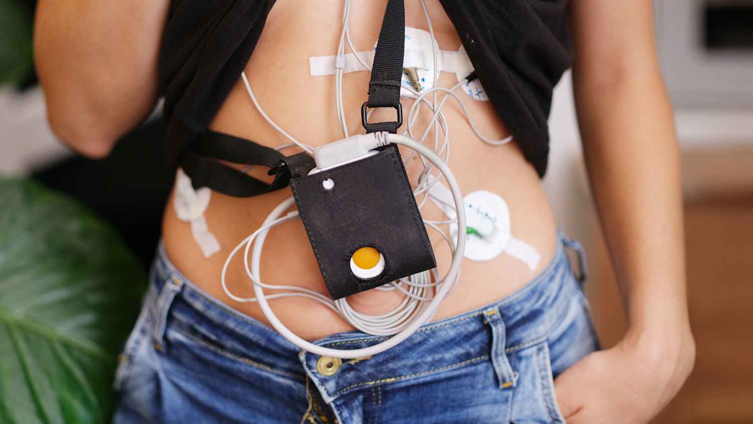 Eine Frau trägt ein Langzeit EKG um den Körper