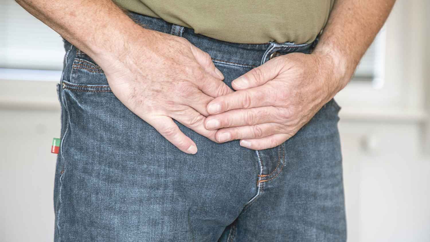 Ein Mann hölt sich die Leiste nach einem Leistenbruch