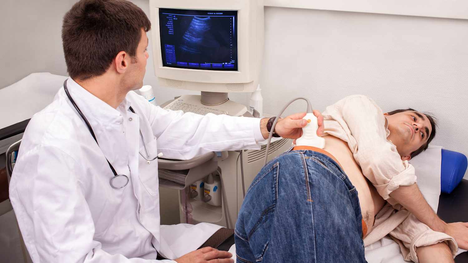 Ein Arzt untersucht einen Patienten mit einem Utraschallgerät