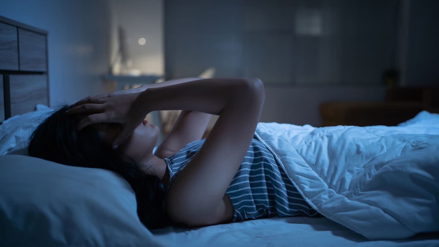 Eine Frau liegt im Bett und kann nicht einschlafen