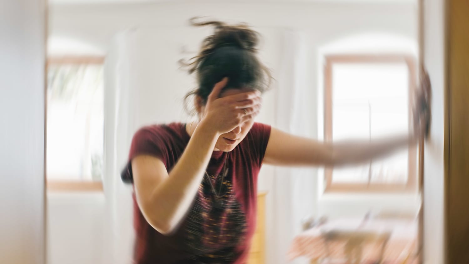 Eine Frau stützt sich mit Schwindel an einer Wand ab