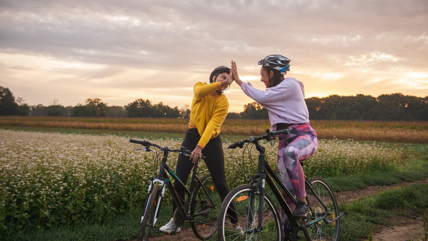 Freundinnen klatschen sich bei einer Fahrradtour ab