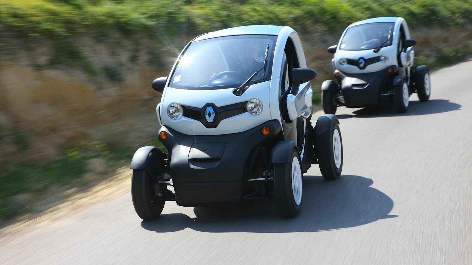 Frontansicht zweier fahrender Renault Twizy