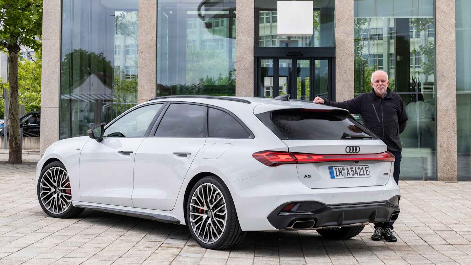 ADAC Redakteur lenkt am Heck eines Audi A5 e-Hybrid