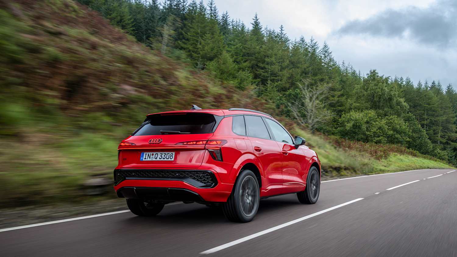 Aufnahme des roten fahrenden Audi Q3 auf einer Landstraße