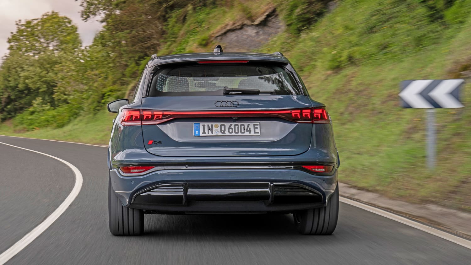 Der Audi Q6 e-tron fahrend von hinten