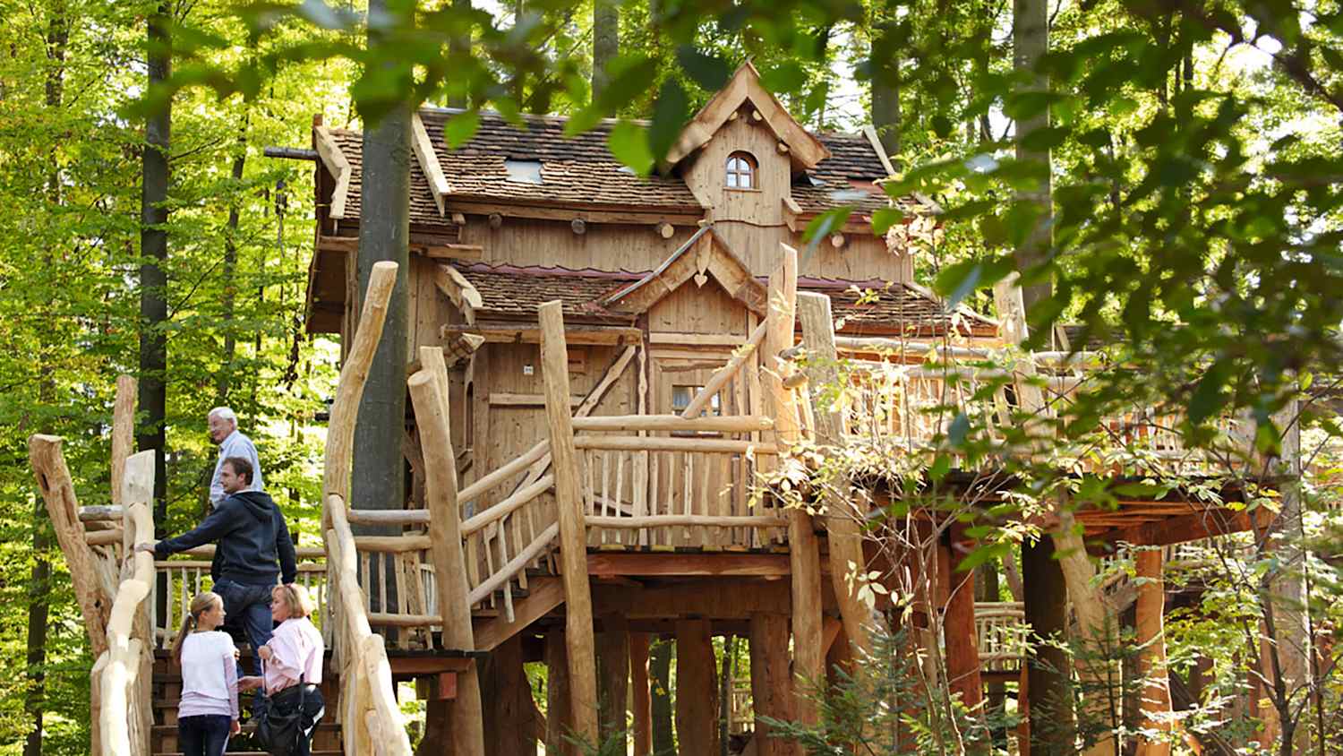 Personen stehen auf der Treppe zu einem Baumhaus in Baden Württemberg Tripsdrill