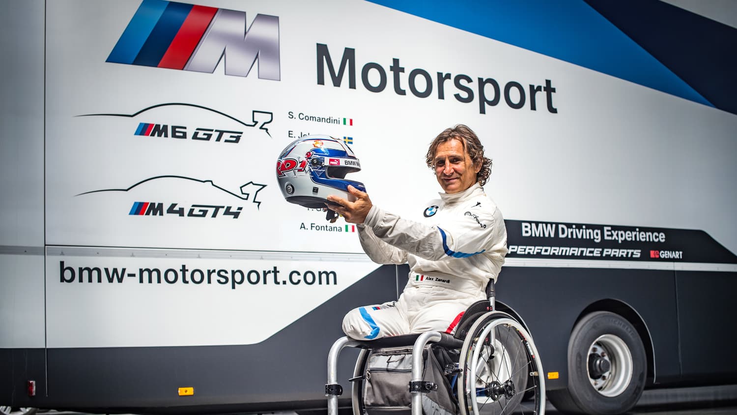 BMW Motorsportler Alessandro Zanardi beim Adria Raceway im Rollstuhl und mit Helm in der Hand