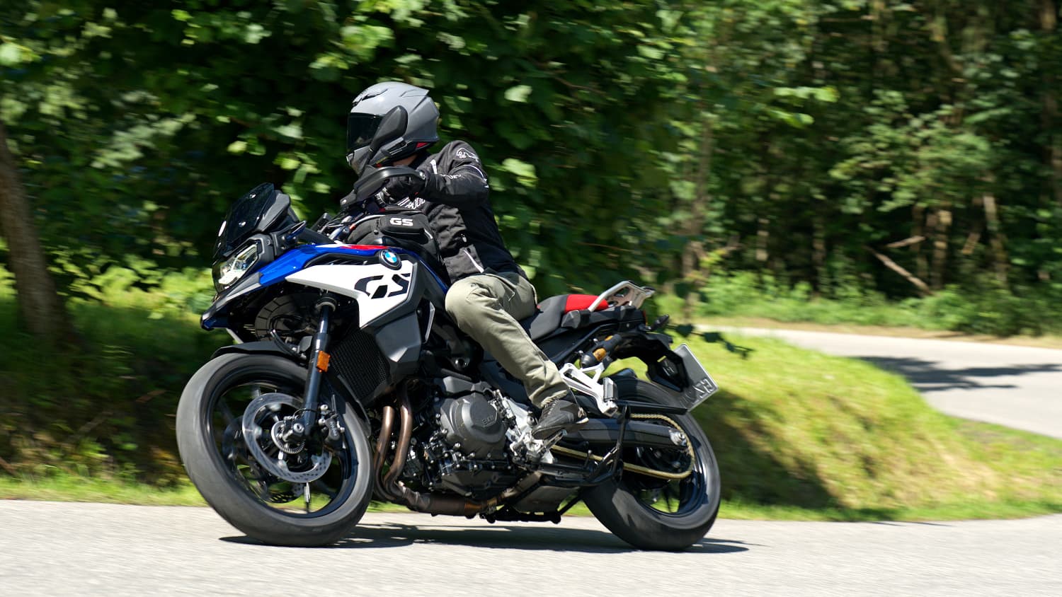 Aufnahme der seitlich fahrenden BMW F 800 GS in einem Wald