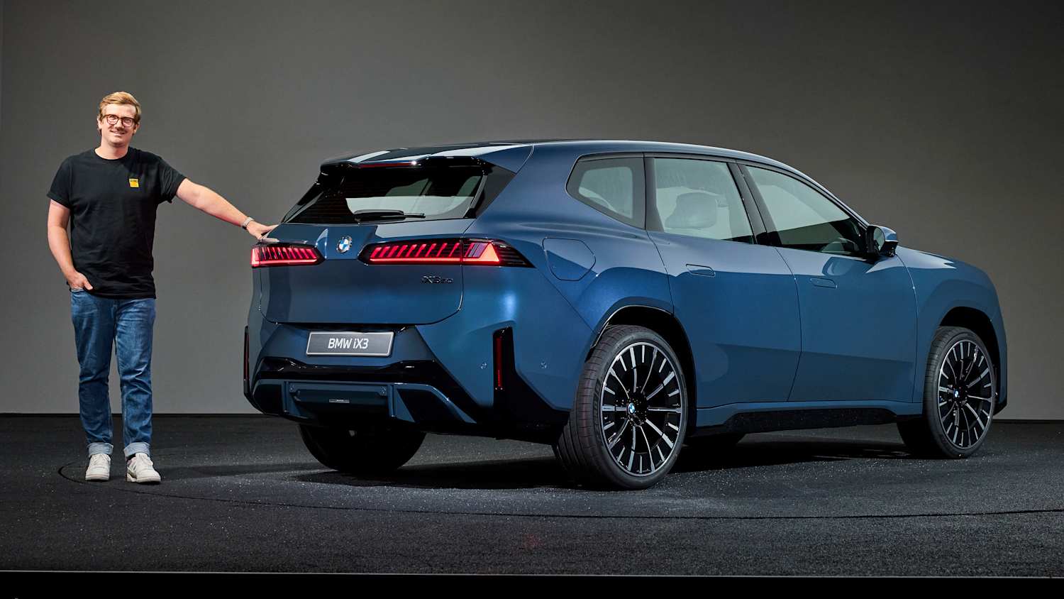 ADAC Redakteur Andreas Huber steht neben einem BMW iX3
