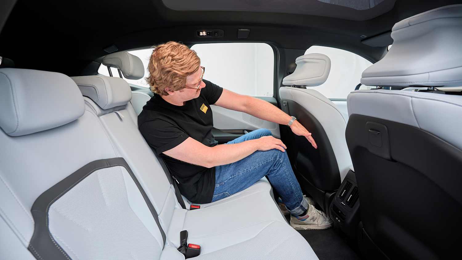 Andreas Huber sitzt auf der Rückbank des BMW iX3