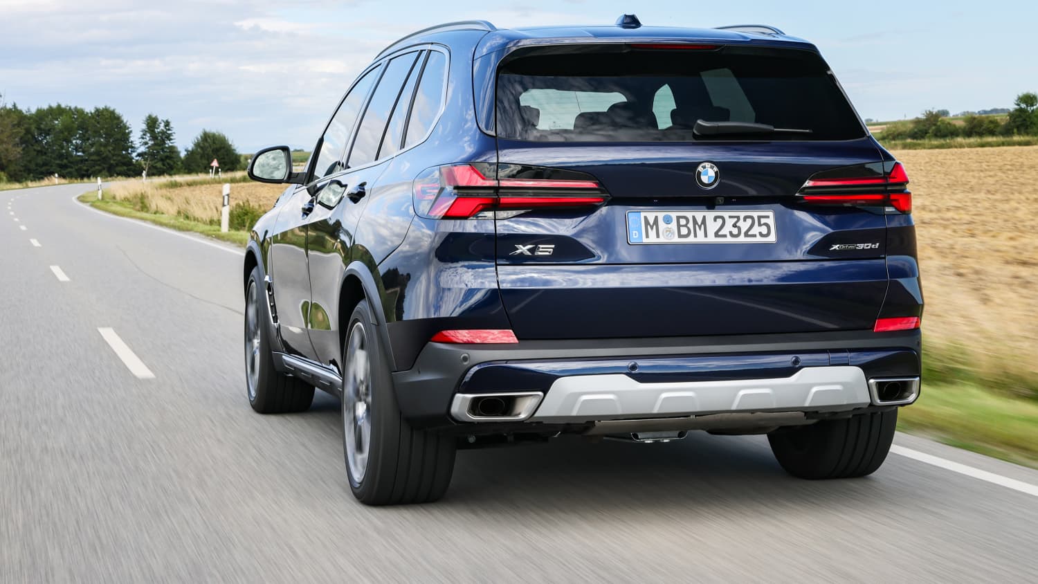 Der neue BMW X5 Faclift Mai 2024 fahrend von hinten zu sehen