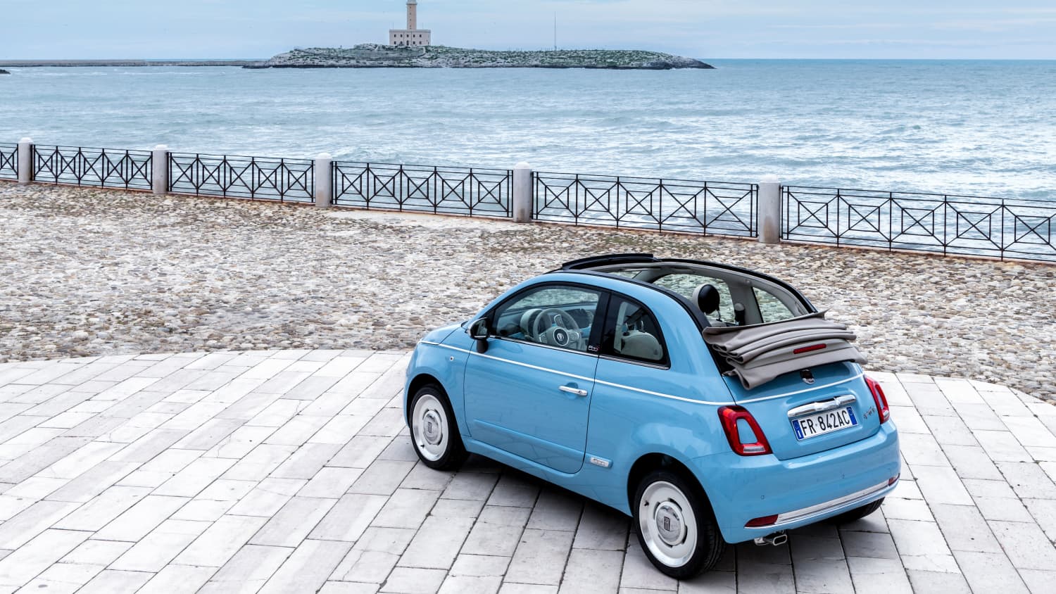 hellblaues Fiat 500 cc Cabrio steht am Meer