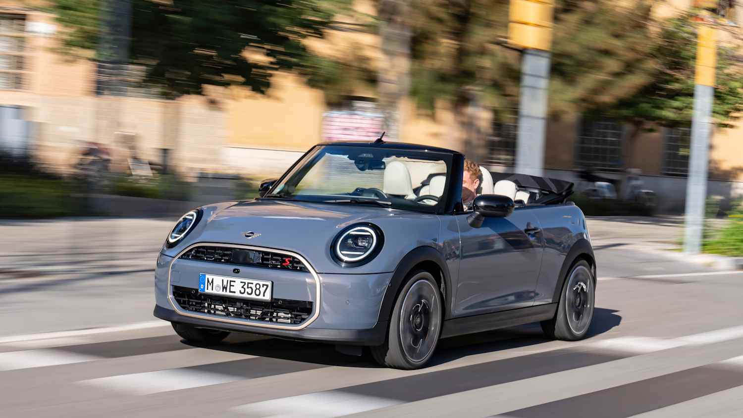 Front und Seitenansicht eines fahrenden Mini Cooper Cabrio
