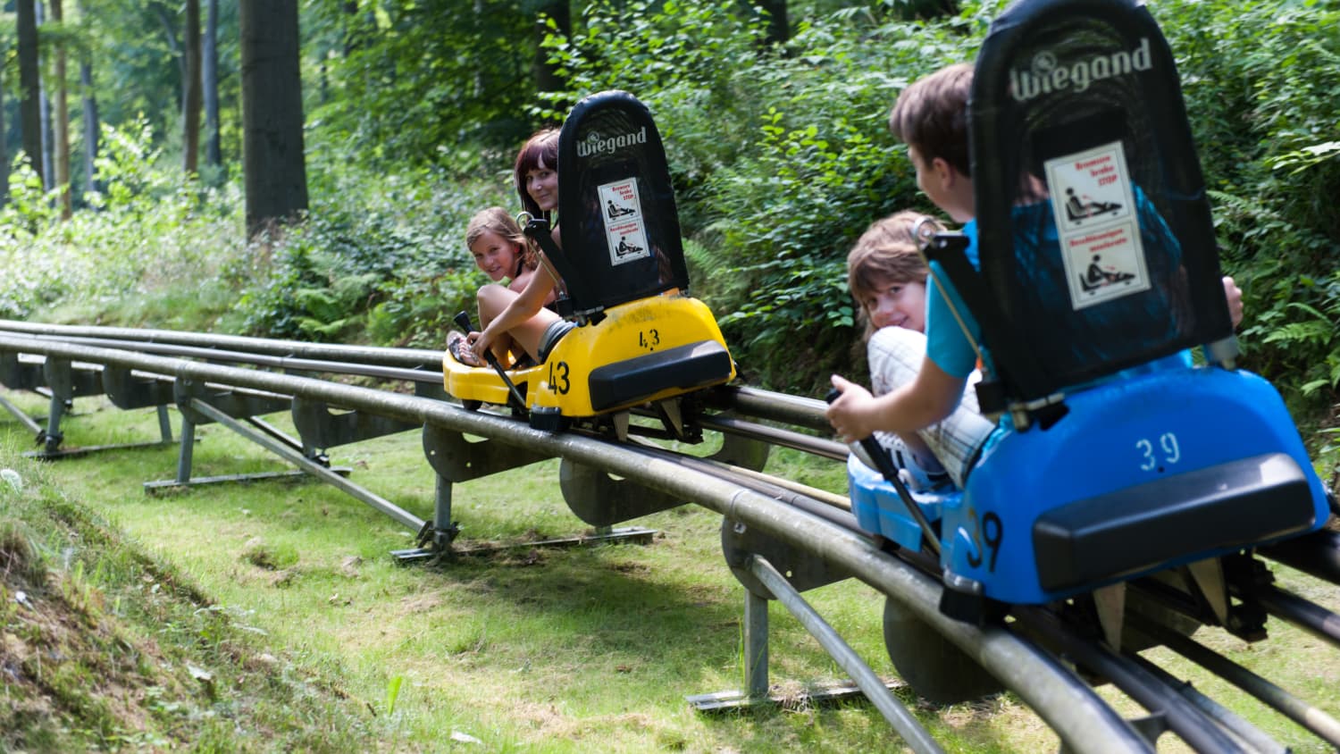 Eine Familie in der Rodelbahn des Seilbahnen Thale Freizeitparkts