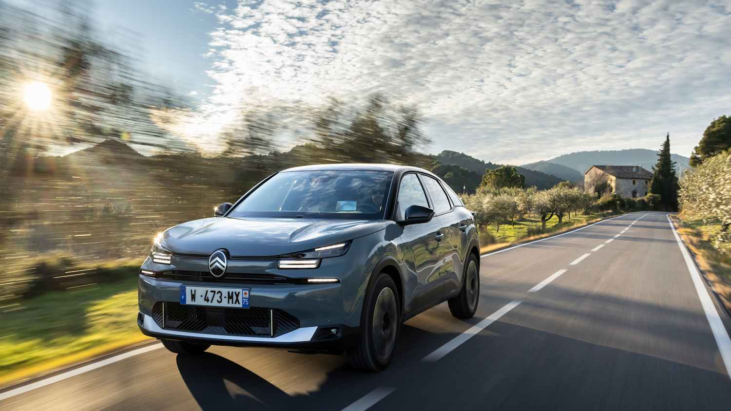 Der neue Citoen C4 Hybrid MAX Manhattan Green fährt durch eine frühlingshafte Landschaft