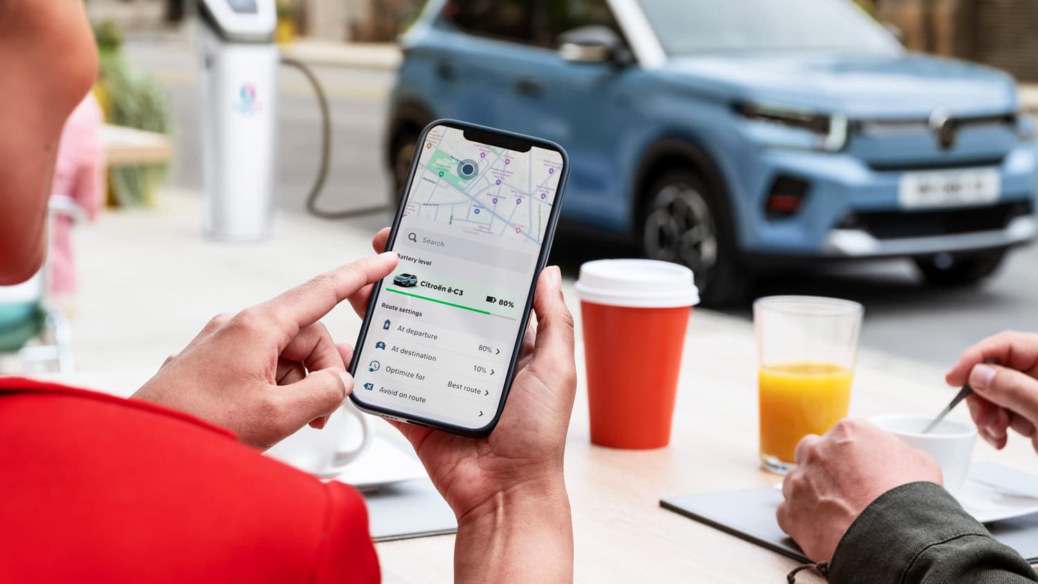 Aufnahme eines Smartphones im Hintergrund ein Citroen E C3